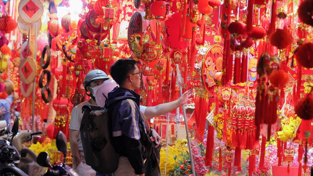 Thời điểm cận Tết, đường Hải Thượng Lãn Ông tấp nập người mua bán. Năm nay, nhiều cửa hàng bày bán các sản phẩm có họa tiết rồng với mong muốn cầu bình an, phú quý. Ảnh: Lạc Hà.