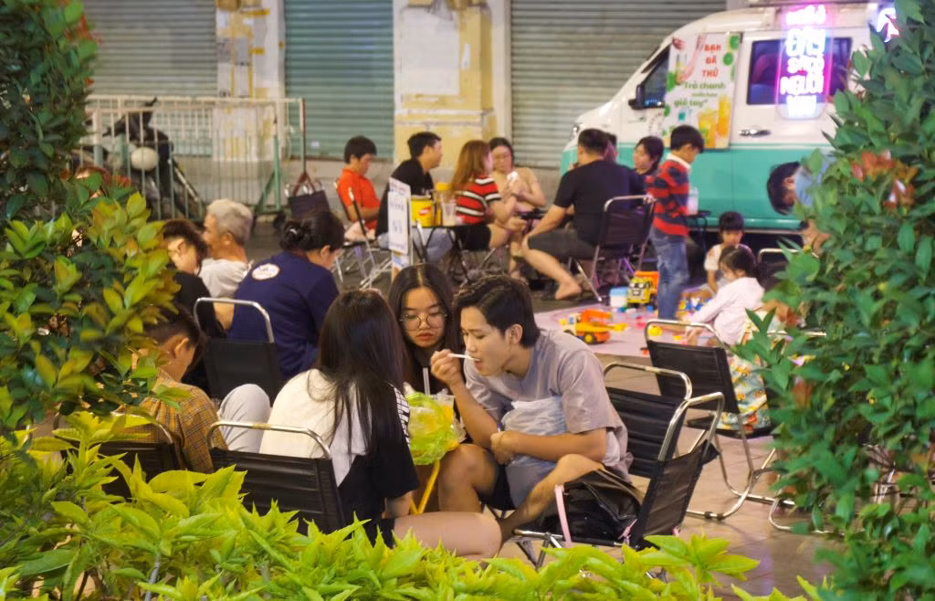 Đêm xuống, nhiều hàng quán được bày bán trước cổng chợ Bình Tây. Nhiều nhóm bạn đến đây để ăn uống, nói chuyện. Ban ngày, chợ thu hút đông đảo bạn trẻ đến check-in, chụp hình Tết. Ảnh: Lạc Hà