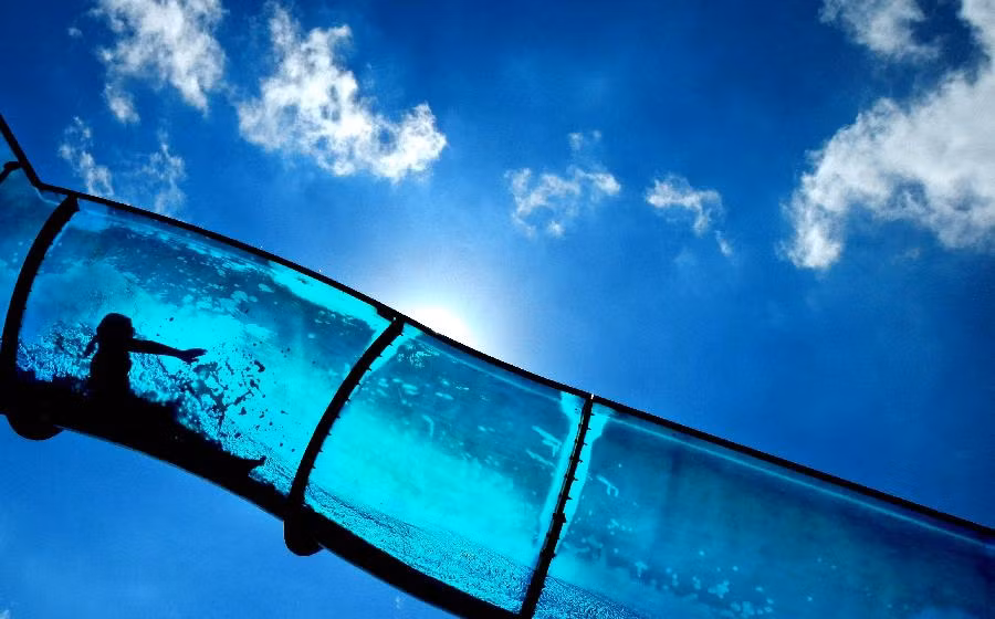 Bóng một bé gái vui thích và phấn kích với trò trượt ống nước trong một bể bơi ngoài trời ngày 10/8.