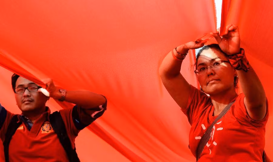 Người biểu tình Áo Đỏ ủng hộ chính phủ Thái Lan dưới dải ruy băng đỏ rực khổng lồ được giăng trên giao lộ Ratchaprasong trong một cuộc biểu tình ngày 10/11.