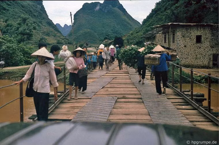 Người dân đi qua một cây cầu gỗ ọp ẹp.