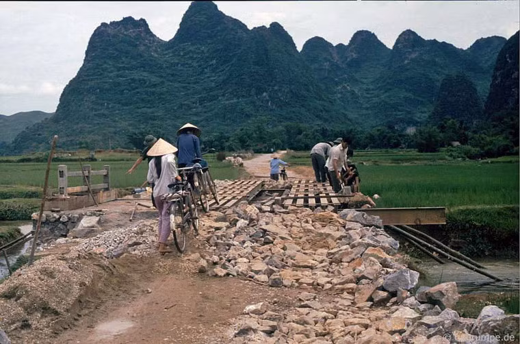 Con đường đang xây dựng dở với cây cầu tạm bắc qua mương.