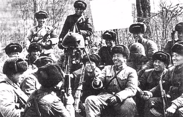 Nhóm lính Trung Quốc hả hê trước một chiếc mũ sắt lỗ chỗ vết đạn của biên phòng Liên Xô.