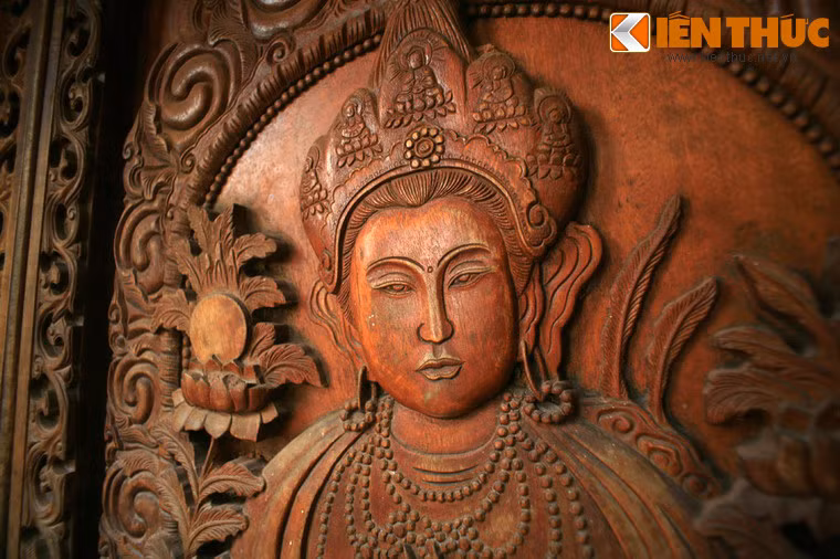 Một cánh cổng bằng gỗ được chạm khắc rất sống động.