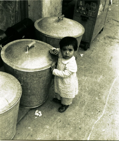 Em bé bên những chiếc nồi luộc bánh chưng.