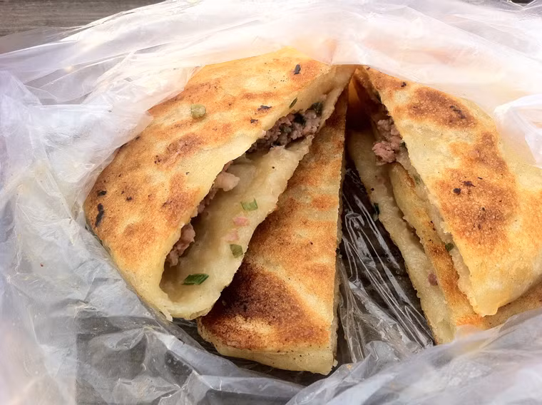 Xian Bing. Là món ăn đường phố giá rẻ, bánh có lớp vỏ bánh làm từ bột lúa mì, bọc lấy phần nhân thịt lợn băm nhỏ trộn với rau rồi làm chín, mang lại cảm giác giòn rụm hấp dẫn.