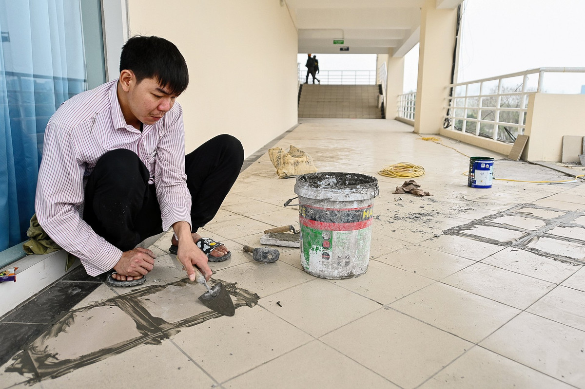 Tại cửa chính của sân vận động đã hoàn thiện phần cổng chào. Phía bên trong sân, hàng trăm thiết bị nội thất phục vụ các phòng chức năng đang được lắp đặt.