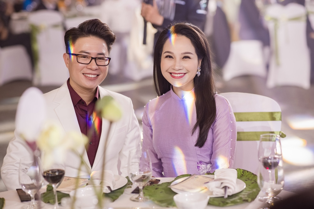 Có mặt trong lễ cưới tối qua là hai MC Mỹ Lan và MC Lê Anh. Mỹ Lan chọn cho mình bộ áo dài truyền thống thêu hoa màu tím, kết hợp lối trang điểm cùng tông. Bộ đôi MC cười tươi khi thấy ống kính máy ảnh.