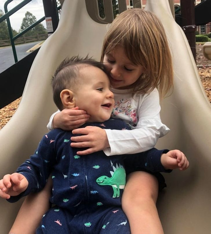 Chị gái vỗ về em trai nhỏ một cách khéo léo.