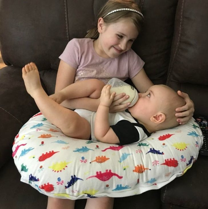 Nụ cười ấm áp của cô bé khi cho em trai chưa đầy 1 tuổi uống sữa.