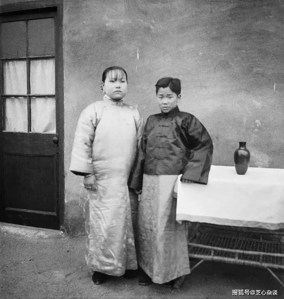 Trong ảnh có một cặp vợ chồng trẻ mới cưới. Điều đáng ngạc nhiên là người vợ lớn tuổi hơn chồng rất nhiều, người chồng mới 13 tuổi và vẫn còn nét trẻ con trên khuôn mặt.