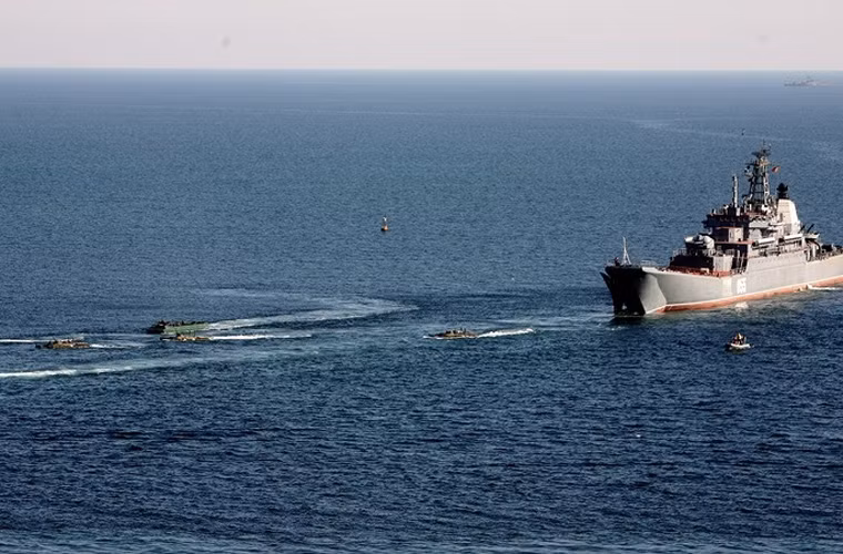 Một số phương tiện thiết giáp lội nước đổ bộ từ ngoài biển, bơi vào bờ.