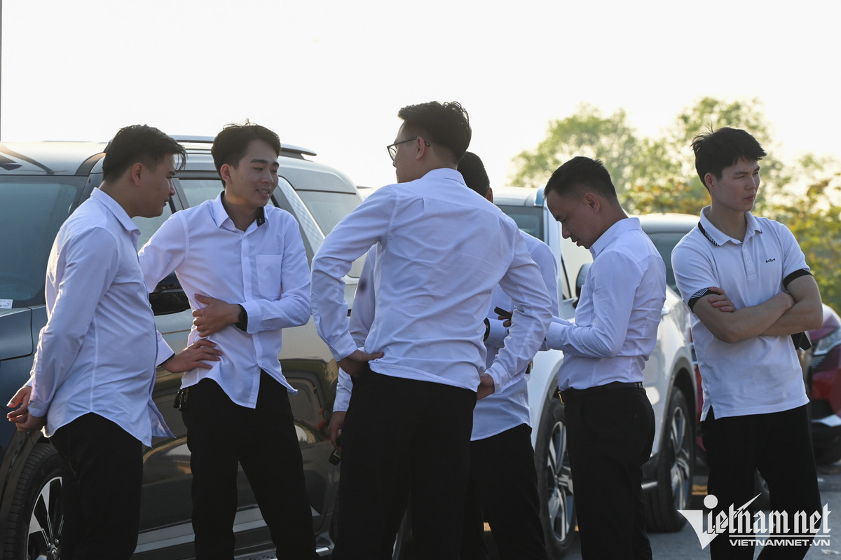 Một nhóm nhân viên của các cửa hàng ô tô ở Hà Nội cũng rủ nhau lái xe về Hưng Yên từ tờ mờ sáng để xếp hàng làm thủ tục. 17h, tất cả họ vẫn đứng chờ, chưa tới lượt, phía trước còn hơn chục chiếc xe nữa. "Gần như tất cả nhân viên ở showroom của tôi đều đổ đi các ngả để xếp hàng đăng kiểm xe mới cho khách. Thiếu nhân sự, đến cả trưởng phòng, phó phòng kinh doanh cũng đi", anh Linh (trái), làm việc tại một showroom ở đường Giải Phóng (Hà Nội) chia sẻ.