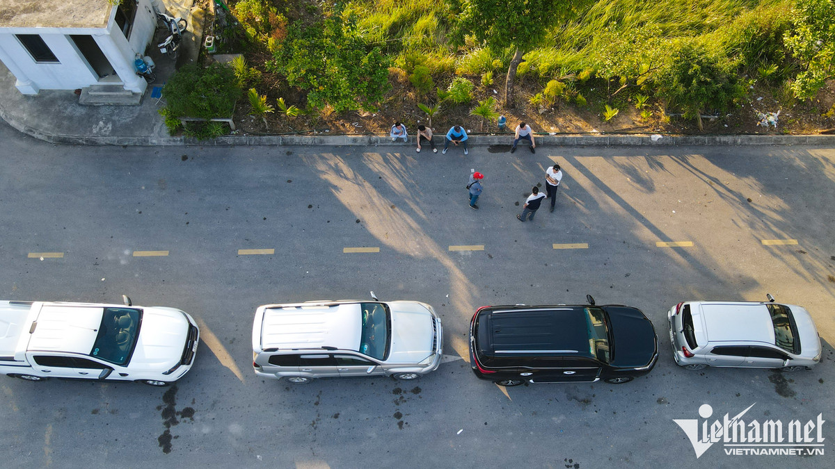 Phía bên trong sân của khu vực đăng kiểm, ô tô xếp hàng dài, các tài xế ra khỏi xe, đứng quây lại để trò chuyện trong khi chờ tới lượt.