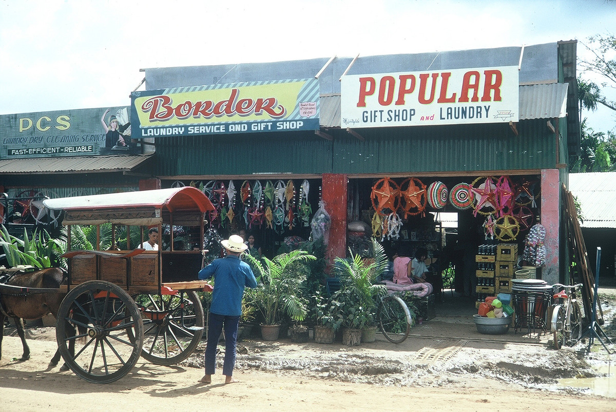 Cửa hàng giặt ủi, quà lưu niệm treo bảng tiếng Anh để mời gọi các binh sĩ Mỹ thường xuyên đi ngang qua tuyến đường này. Ảnh: William Smith.