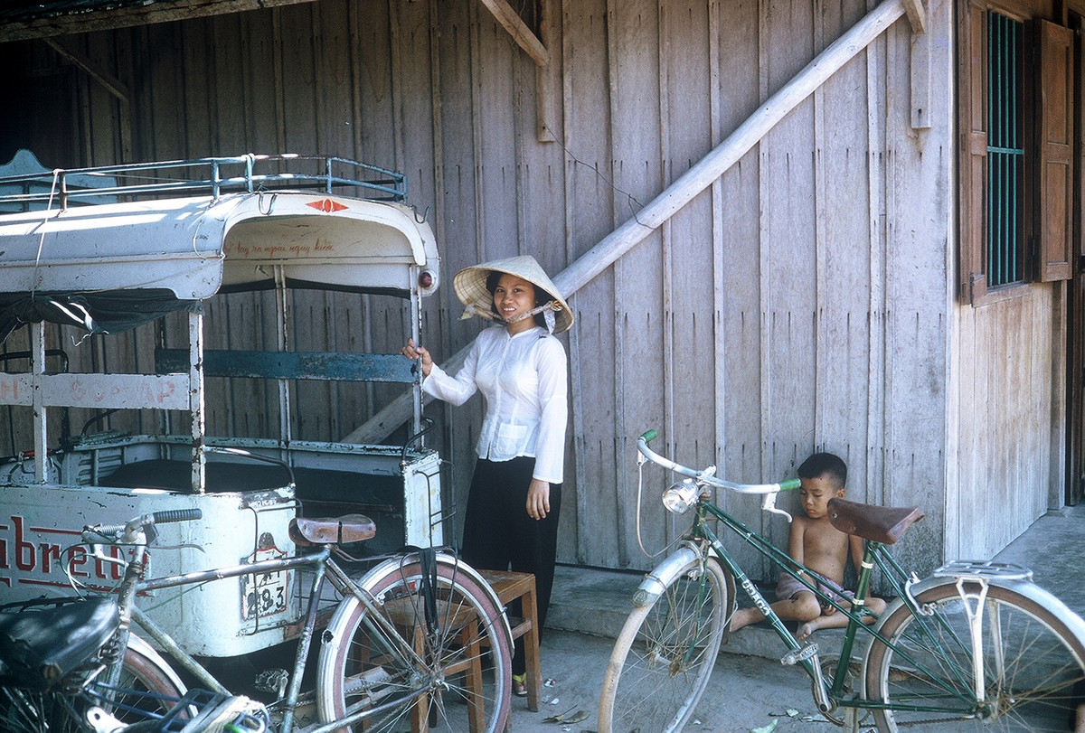 Cô gái bên chiếc xe chở khách Lambretta đỗ bên ngoài một ngôi nhà ở Củ Chi. Ảnh: William Smith.