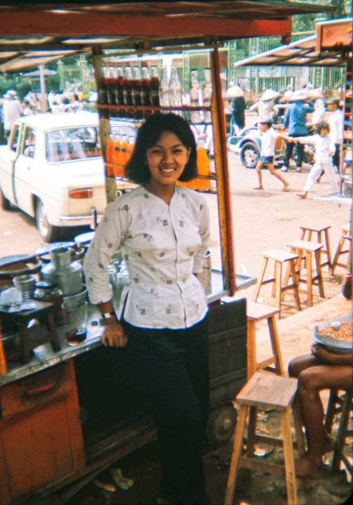 Nụ cười của cô gái bán nước giải khát trước Thảo Cầm Viên, 1965. Ảnh: Tom Robinson.