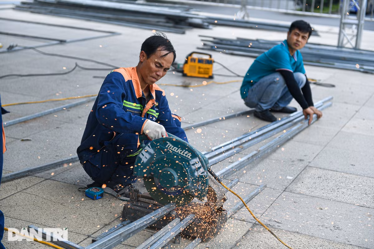 "Chúng tôi gồm hơn 10 người bắt đầu thi công, dựng rạp bên ngoài từ ngày hôm qua 17/7. Chúng tôi chủ yếu vận chuyển sắt thép để lắp ráp. Mỗi người mỗi việc, người hàn, người cắt sắt còn một đội chuyên lắp đặt", một công nhân chia sẻ.