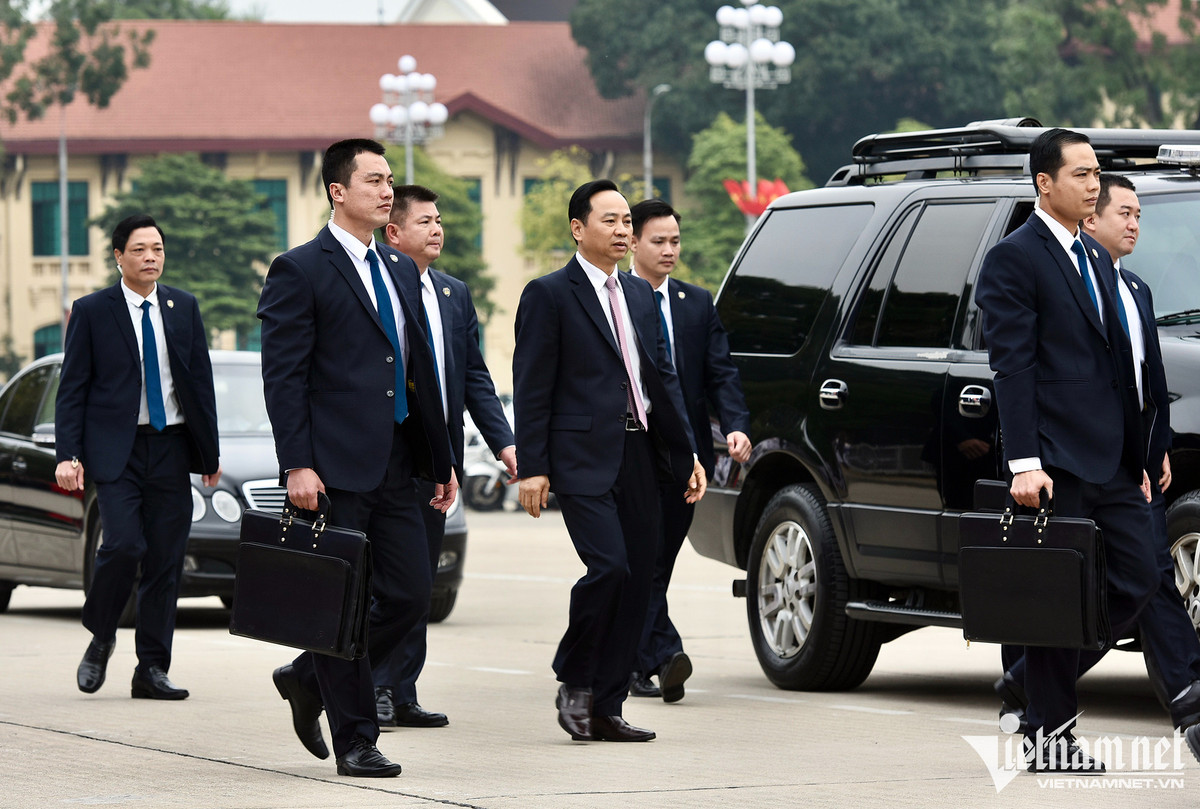 Hộ tống đoàn xe bảo vệ còn có hàng chục cảnh vệ mặc vest đen đi trên hai ôtô.