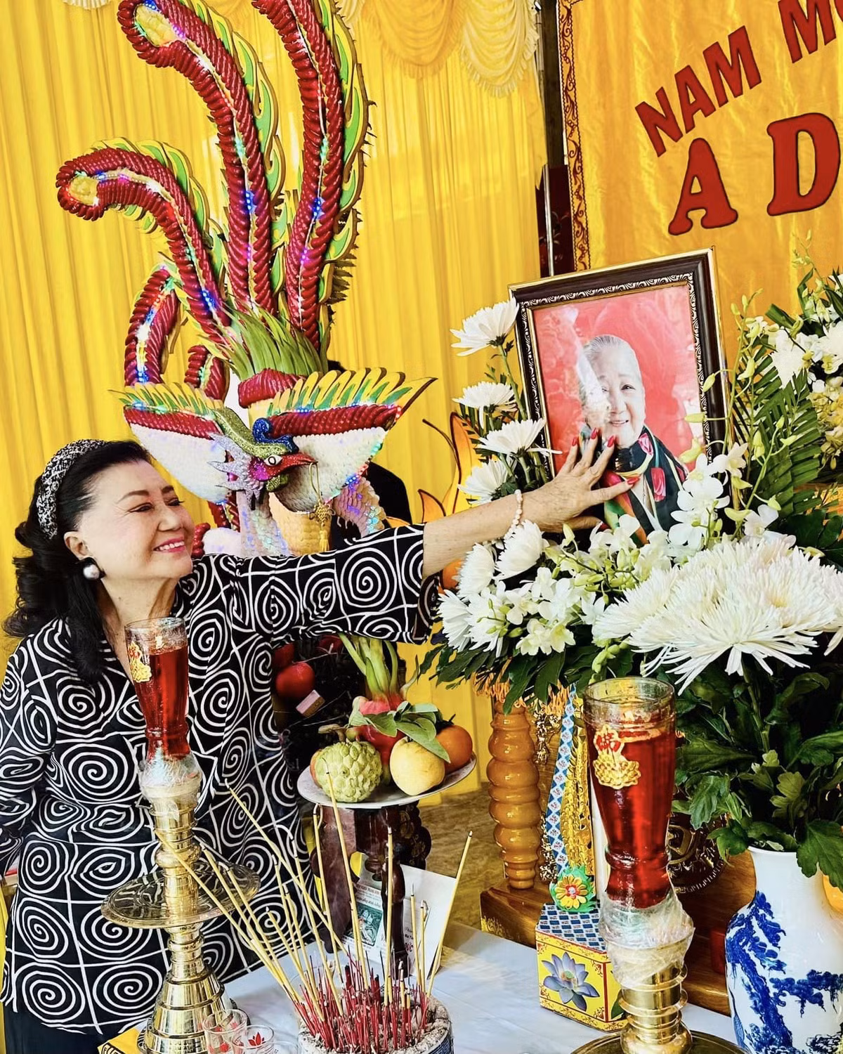 NSND vuốt ve di ảnh đàn chị. Bà nói, Thiên Kim là cô đào đắt show nhất Khu dưỡng lão nghệ sĩ, luôn san sẻ niềm vui và tinh thần lạc quan cho mọi người.