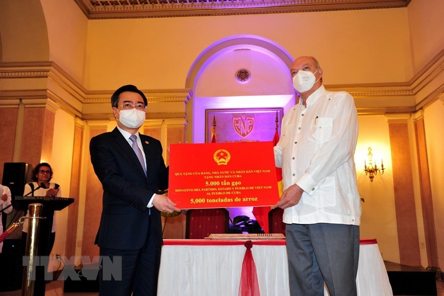 Bộ trưởng Bộ Xây dựng Nguyễn Thanh Nghị trao tượng trưng cho Bộ trưởng Ngoại thương và Đầu tư nước ngoài Cuba Rodrigo Malmierca Díaz món quà 5.000 tấn gạo của Nhà nước và nhân dân Việt Nam tặng nhân dân Cuba (2021). (Ảnh: Lê Hà/TTXVN).