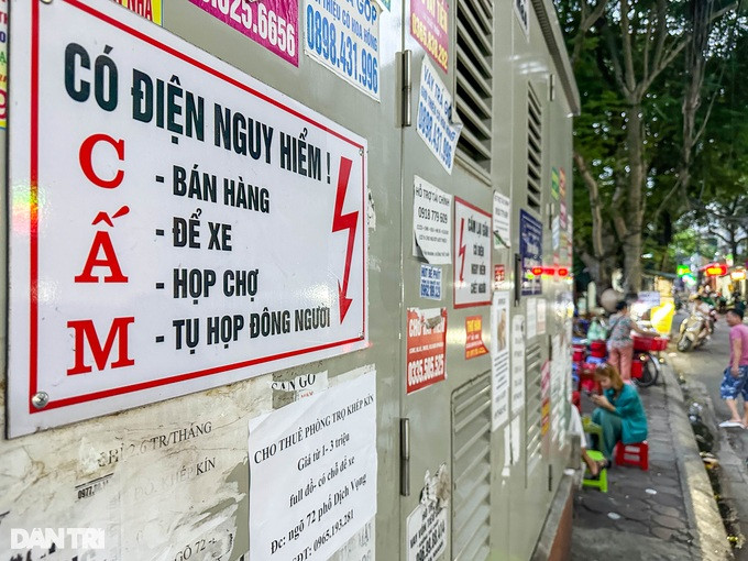 Trạm biến áp trên phố Dịch Vọng có gắn biển cấm: Bán hàng, để xe, họp chợ, tụ tập đông người. Song một số người dân cố tình phớt lờ biển cấm, bán hàng ngay bên cạnh trạm biến áp.