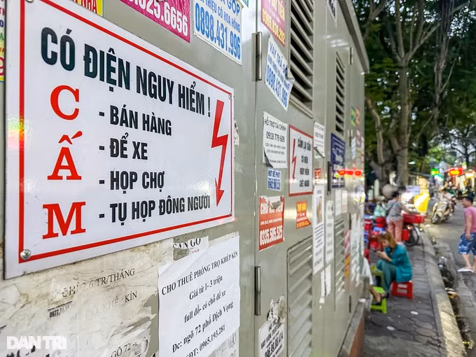 Trạm biến áp trên phố Dịch Vọng có gắn biển cấm: Bán hàng, để xe, họp chợ, tụ tập đông người. Song một số người dân cố tình phớt lờ biển cấm, bán hàng ngay bên cạnh trạm biến áp.
