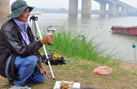 Giáo sư Vũ Văn Bằng đo đạc bên bờ sông Hồng.