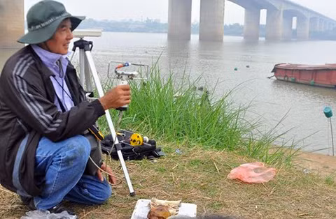 Giáo sư Vũ Văn Bằng đo đạc bên bờ sông Hồng.