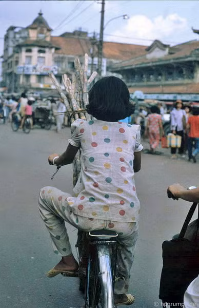 Một người phụ nữ chở mía bằng xe đạp gần chợ Bình Tây.