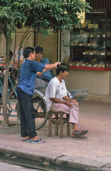 Chỉ cần một cái ghế gỗ đặt trên vỉa hè là đủ để hành nghề.