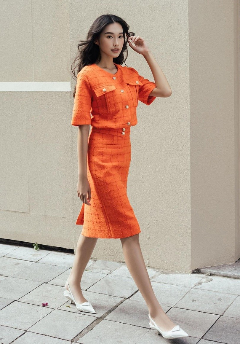 Doãn Hải My nổi bật với bộ cánh màu cam rực rỡ cùng giày gót đế thấp, sải bước trên đường phố Thủ đô. (Ảnh: Lê Tuấn Anh)