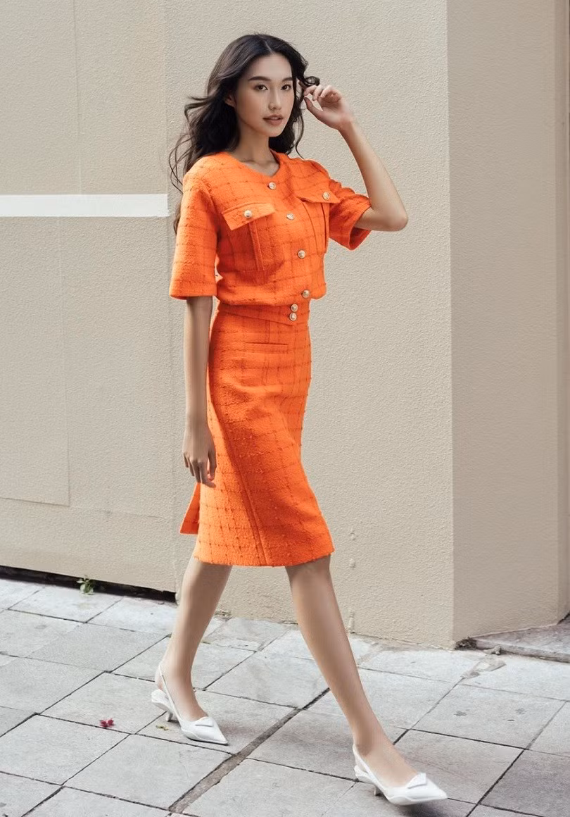 Doãn Hải My nổi bật với bộ cánh màu cam rực rỡ cùng giày gót đế thấp, sải bước trên đường phố Thủ đô. (Ảnh: Lê Tuấn Anh)
