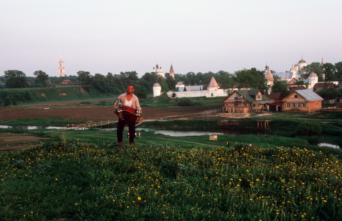 Người đàn ông chơi đàn accordion trên cánh đồng.