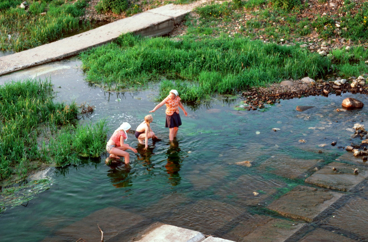 Phụ nữ và trẻ em địa phương tắm sông.