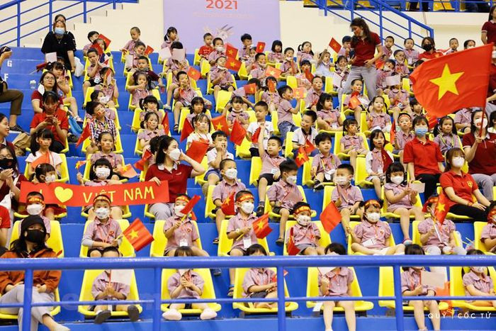 Các em nhỏ cầm cờ Việt Nam đi cổ vũ tuyển thể dục nghệ thuật tại nhà thi đấu Quần Ngựa (Hà Nội). (Ảnh: Ngô Trần Hải An/Vietnam+)