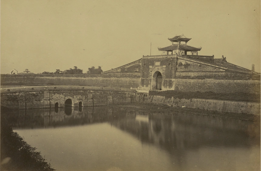 Theo sách Sài Gòn Chợ Lớn ký ức đô thị và con người của Nguyễn Đức Hiệp, Émile Gsell (1838-1879) là nhà nhiếp ảnh chuyên nghiệp và thương mại đầu tiên ở Sài Gòn. Ông chụp nhiều hình ảnh về cảnh quan, đời sống, chân dung con người ở Việt Nam, trong đó có ảnh về miền Bắc (chụp khoảng những năm 1875-1879). Bức ảnh này cho thấy một trong những cổng của thành Hà Nội, được xây dựng vào năm 1805 theo mô hình của các thành Vauban. Nhiều công trình đã bị phá hủy bởi người Pháp từ năm 1894 đến năm 1897; chỉ một số ít di tích còn sót lại.