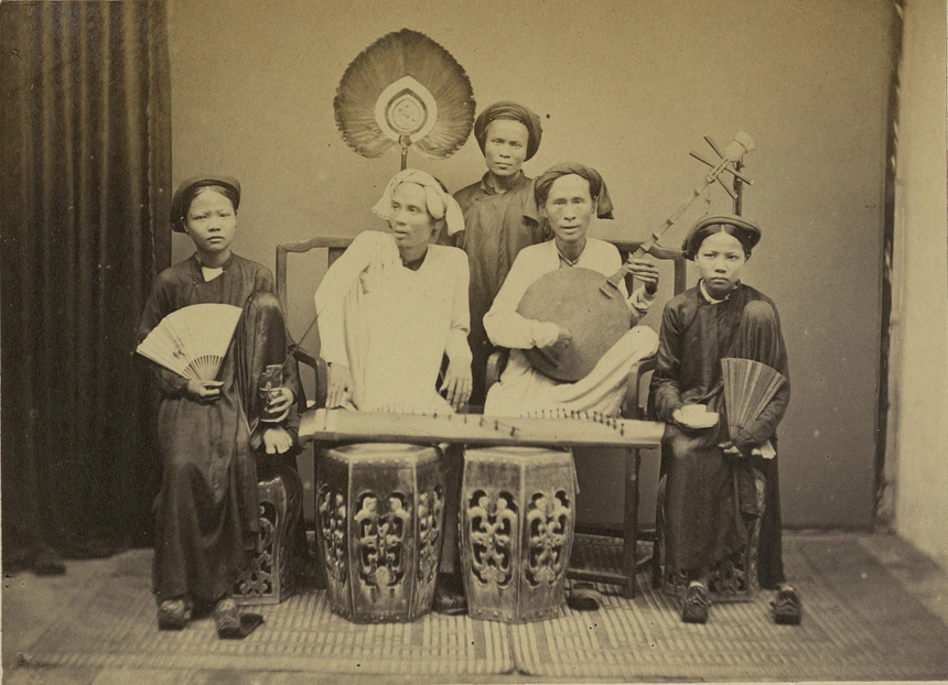 Nhóm người mặc áo dài, đầu đội khăn hoặc vấn tóc, mang theo nhạc cụ.