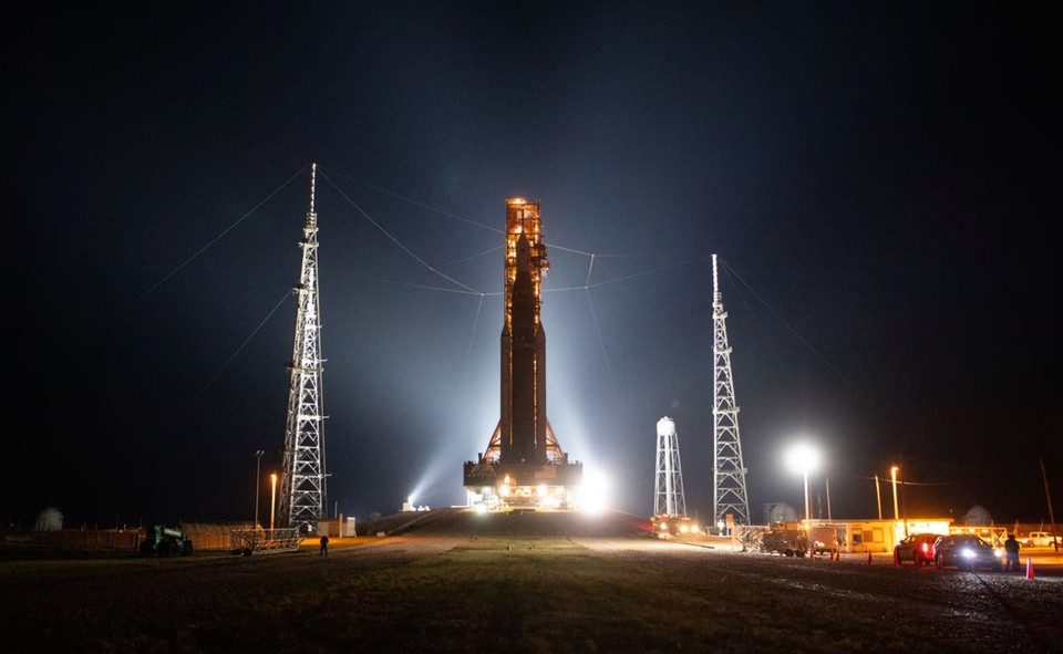 br/> Tên lửa SLS (Space Launch System – Hệ thống Phóng Không gian) cùng tàu vũ trụ Orion cập bến bệ phóng 39B tại Trung tâm Vũ trụ Kennedy vào ngày 17/8. SLS là tên lửa mạnh nhất từng được Cơ quan Hàng không Vũ trụ Mỹ (NASA) chế tạo, lực đẩy mạnh hơn 15% so với tên lửa Saturn V dùng trong sứ mệnh Apollo cách đây nửa thế kỷ. Ảnh: NASA.