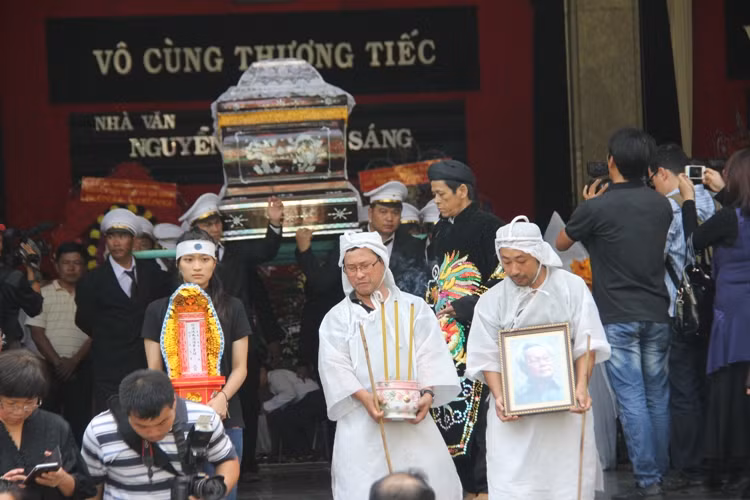 Đạo diễn Nguyễn Quang Dũng cầm di ảnh cha giờ tiễn biệt.