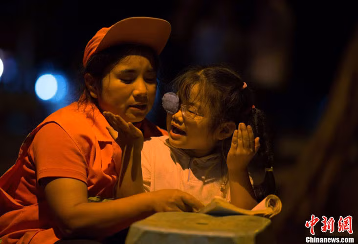 Cô bé Tang ngoan ngoãn hiểu được nỗi lòng của người mẹ nghèo nên vui vẻ theo mẹ đi làm và học bài bền lề đường.