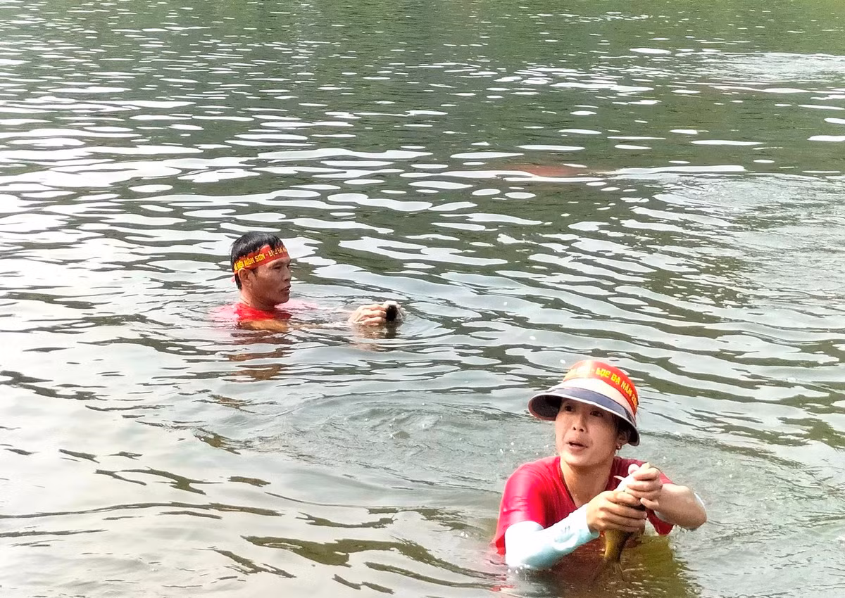 Bắt được cá, những người dưới nước và trên bờ đều hò reo cổ vũ.