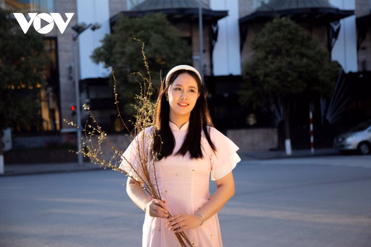 Để tạo điểm nhấn khi chụp ảnh với áo dài Tết, một số người còn tương tác cùng những cành hoa mùa xuân