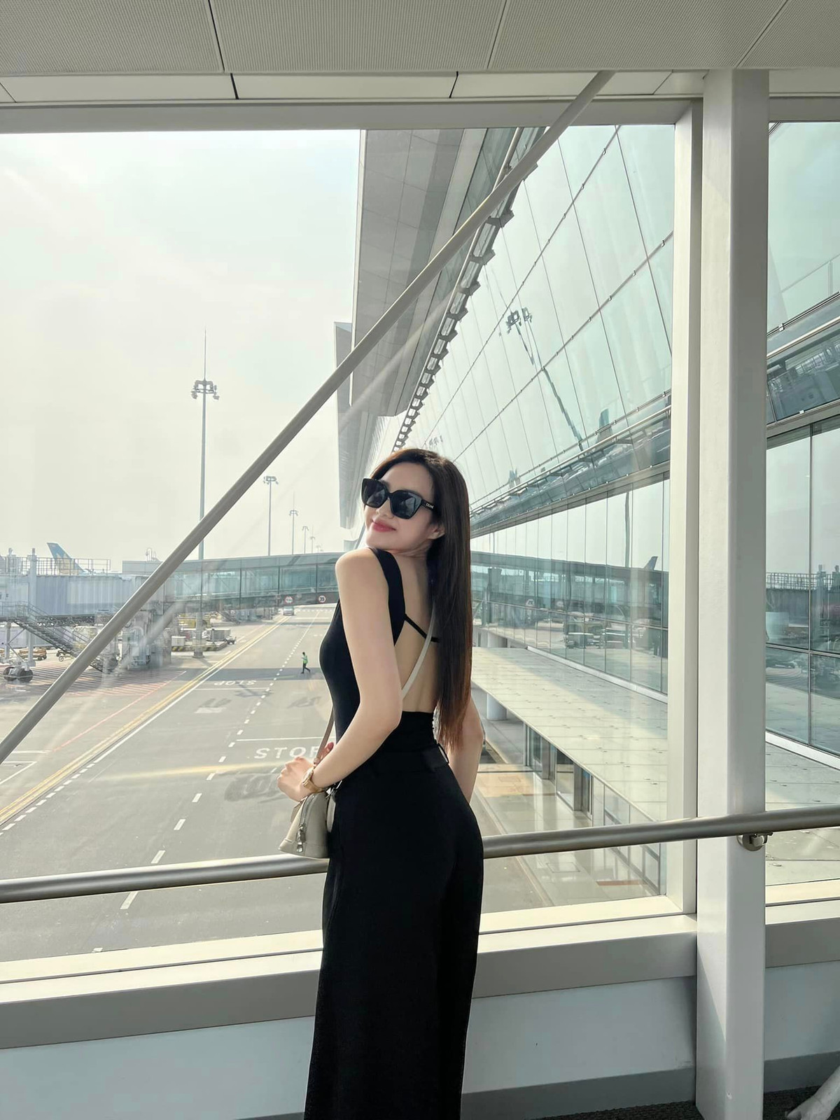 Hoa hậu Đỗ Thị Hà diện jumpsuit màu đen, khoe lưng trần khi ra sân bay để đi Thái Lan dịp nghỉ lễ 30/4.