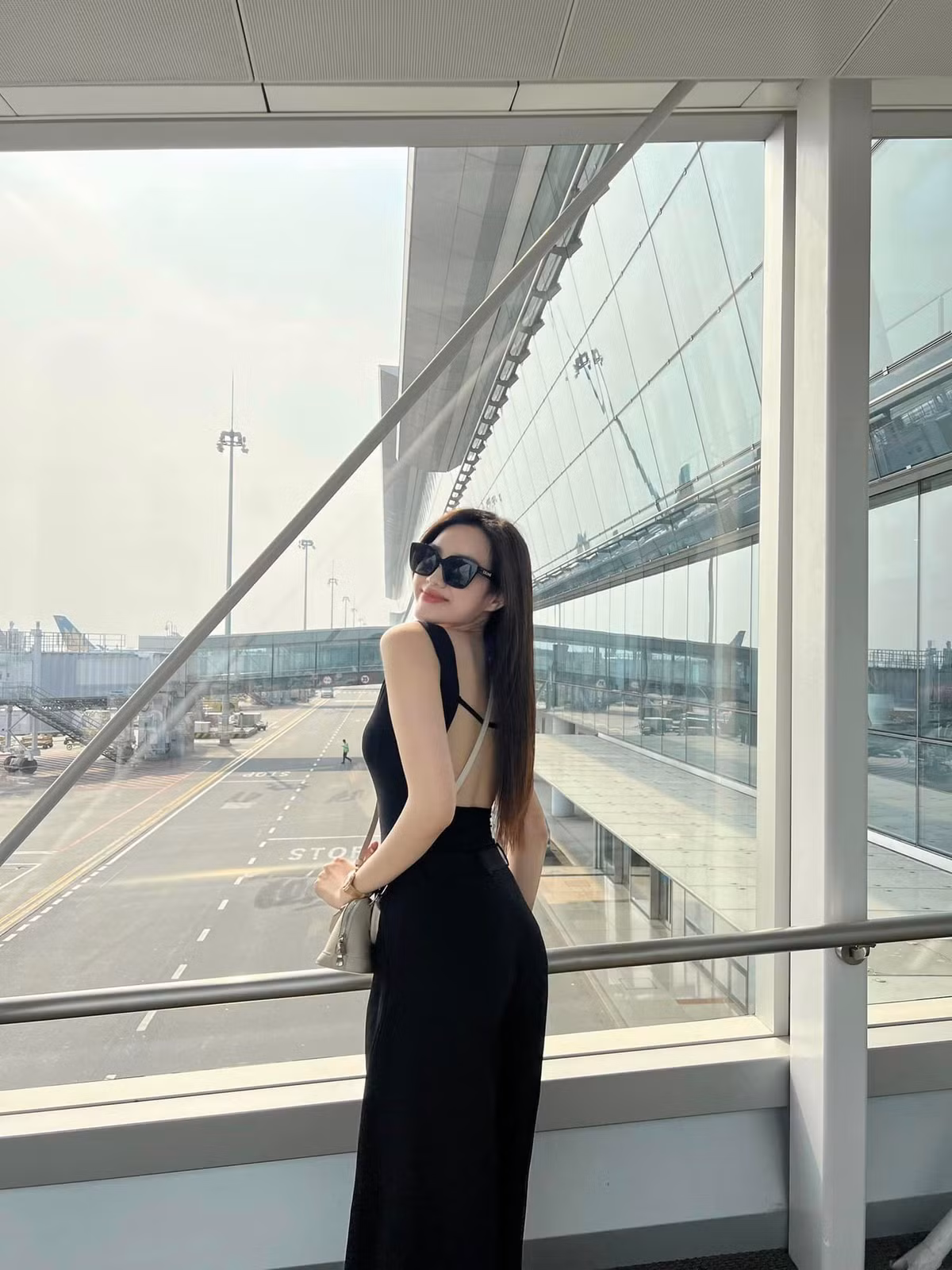 Hoa hậu Đỗ Thị Hà diện jumpsuit màu đen, khoe lưng trần khi ra sân bay để đi Thái Lan dịp nghỉ lễ 30/4.