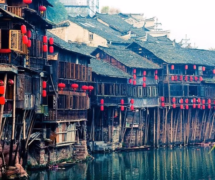  Phượng Hoàng Cổ Trấn có tuổi đời hàng trăm năm với nhiều loại hình kiến trúc khác biệt. Nổi bật là Điếu cước lâu, loại nhà sàn cổ giao thoa giữa kiến trúc truyền thống dân tộc Miêu và văn hóa của người Hán. Khác với nhà sàn thường thấy với toàn bộ ngôi nhà được dựng trên cột gỗ, Điếu cước lâu chỉ có một nửa sàn tựa trên các hàng cột chống vào sườn núi hay xuống mặt nước.