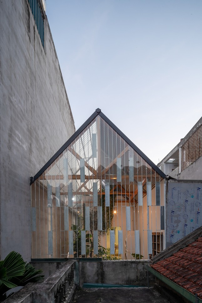 Mái nhà và các mặt bao che trước sau được ví như một chiếc áo mưa, trùm lên khối nhà cũ, bảo vệ phần tường, sàn khỏi xuống cấp do thời tiết. Do phần hiện trạng đã được xây dựng khá lâu và xuống cấp, "áo" bao che được thiết kế với trọng lượng nhẹ nhất, bao gồm sắt, tấm lợp và gỗ - các vật liệu phổ biến ở địa phương.