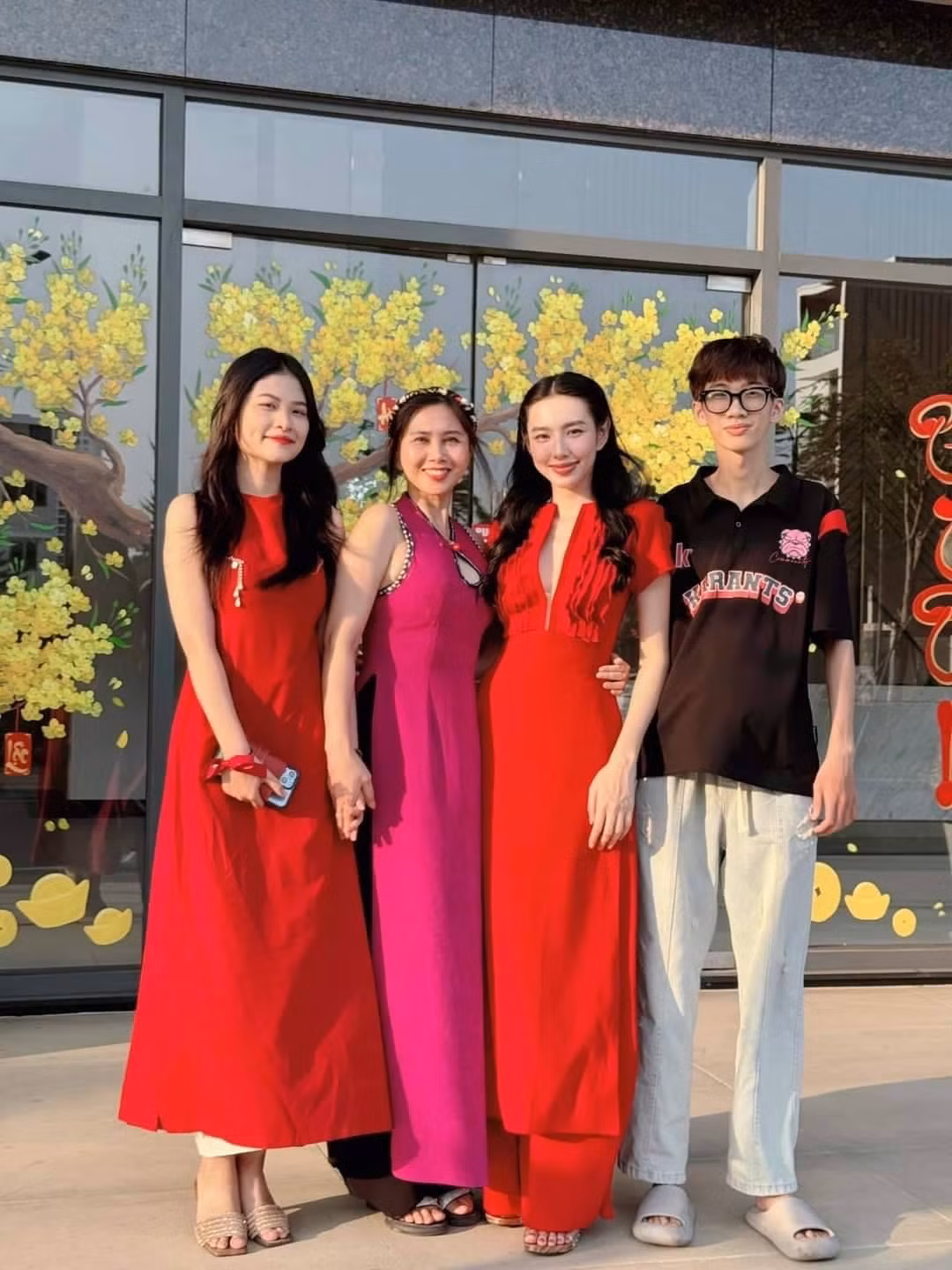 Hoa hậu Thùy Tiên mặc áo dài kiểu cổ xẻ hiện đại khi đi chơi cùng gia đình trong ngày Mùng 2 Tết.