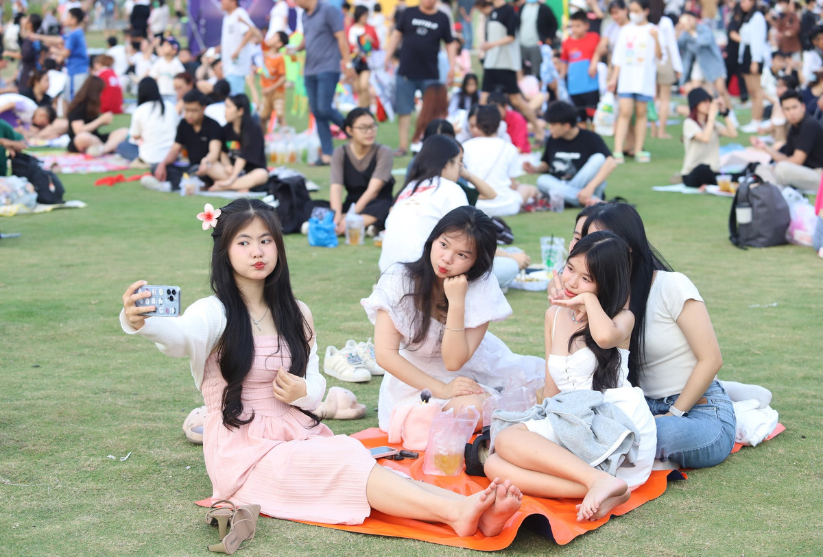 Nhiều nhóm bạn trẻ trải bạt ngồi trò chuyện, ăn uống và tán chuyện cùng nhau trong khoảng thời gian rảnh ngày cuối tuần.