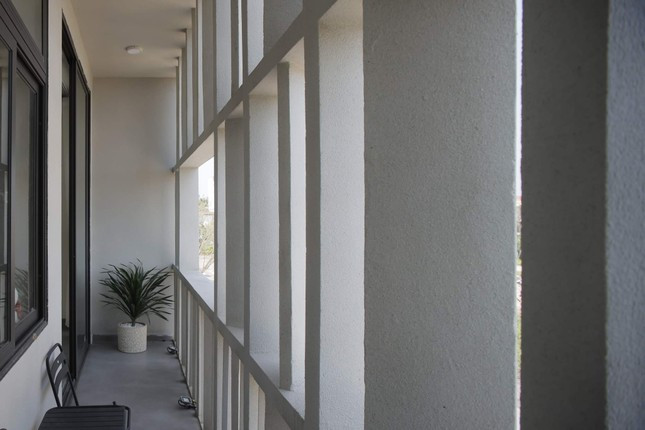 Phía sau hệ lam mặt tiền là lô-gia nhỏ đủ để gia chủ có những giây phút lặng lẽ thả lỏng. Không gian chung theo lời kiến trúc sư: "như một khối bột mỳ được nhào thành cục và kéo căng ra" khiến các khoảng sinh hoạt chung được chia nhỏ trộn lẫn với hành lang tăng sự kết nối giữa bên trong và bên ngoài, đồng thời tạo nên hình thái mới trong tỷ lệ không gian kiến trúc. 